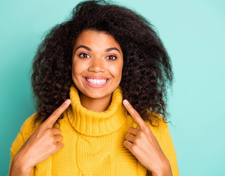 African-American woman pointing at her teeth in Stafford, VA