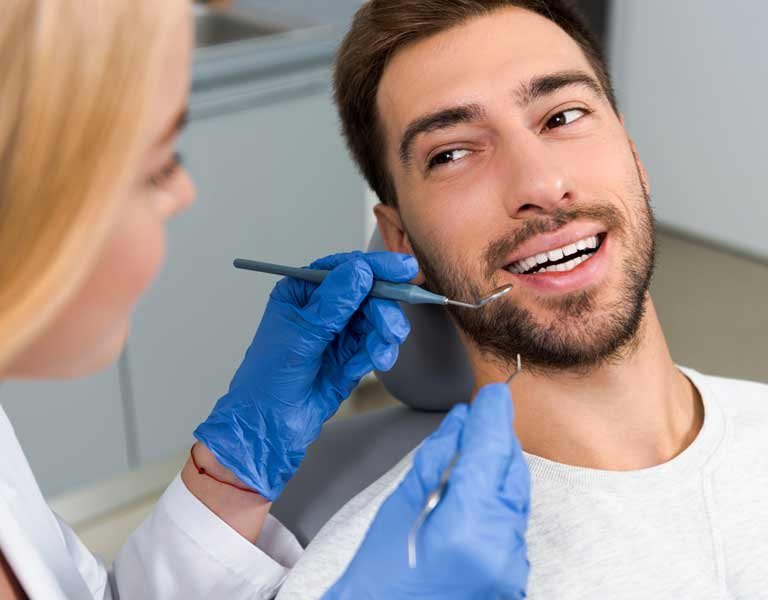 Dentist examining the teeth of a young, happy patient in Stafford, VA