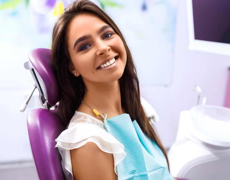 Woman sitting in a dentist's chair during a dental procedure at a dental clinic in Stafford, VA