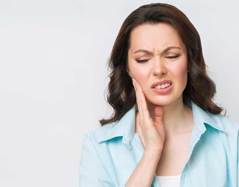 Young woman experiencing severe jaw pain at a dental clinic in Stafford, VA
