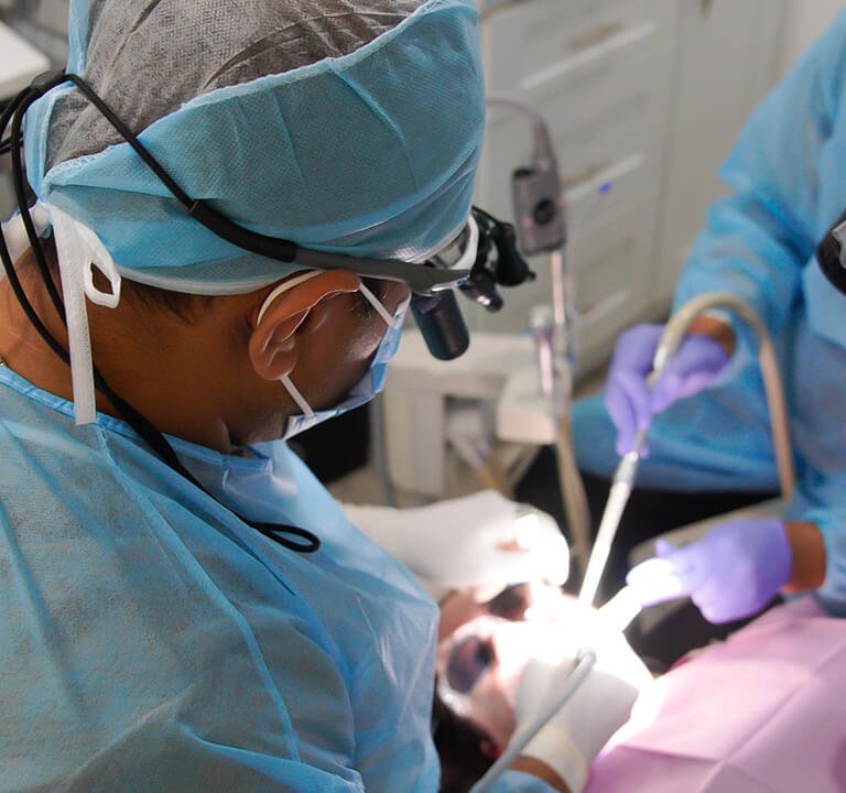 A dentist performing a surgery at Karande Biological Dentistry